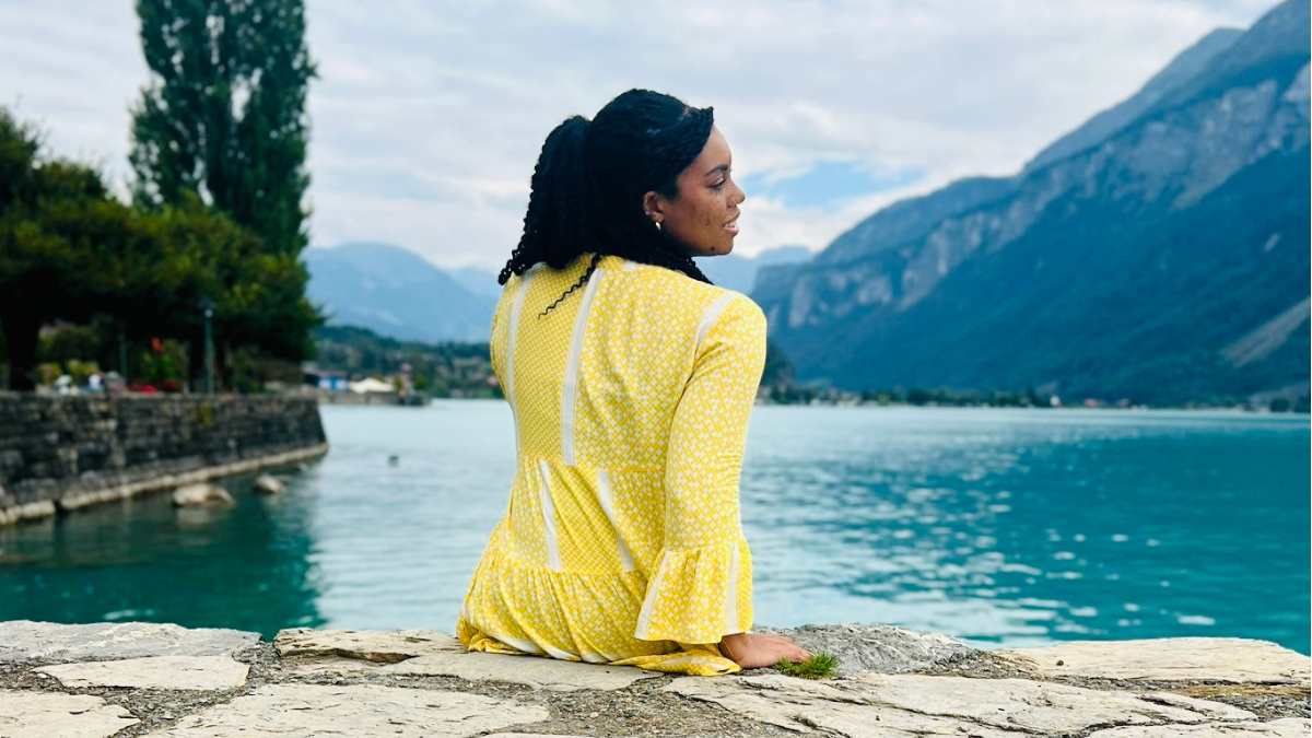 Woman, Keri, sitting on the edge of a ledge overlooking a lake