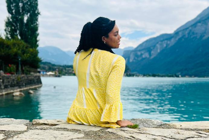 Woman, Keri, sitting on the edge of a ledge overlooking a lake